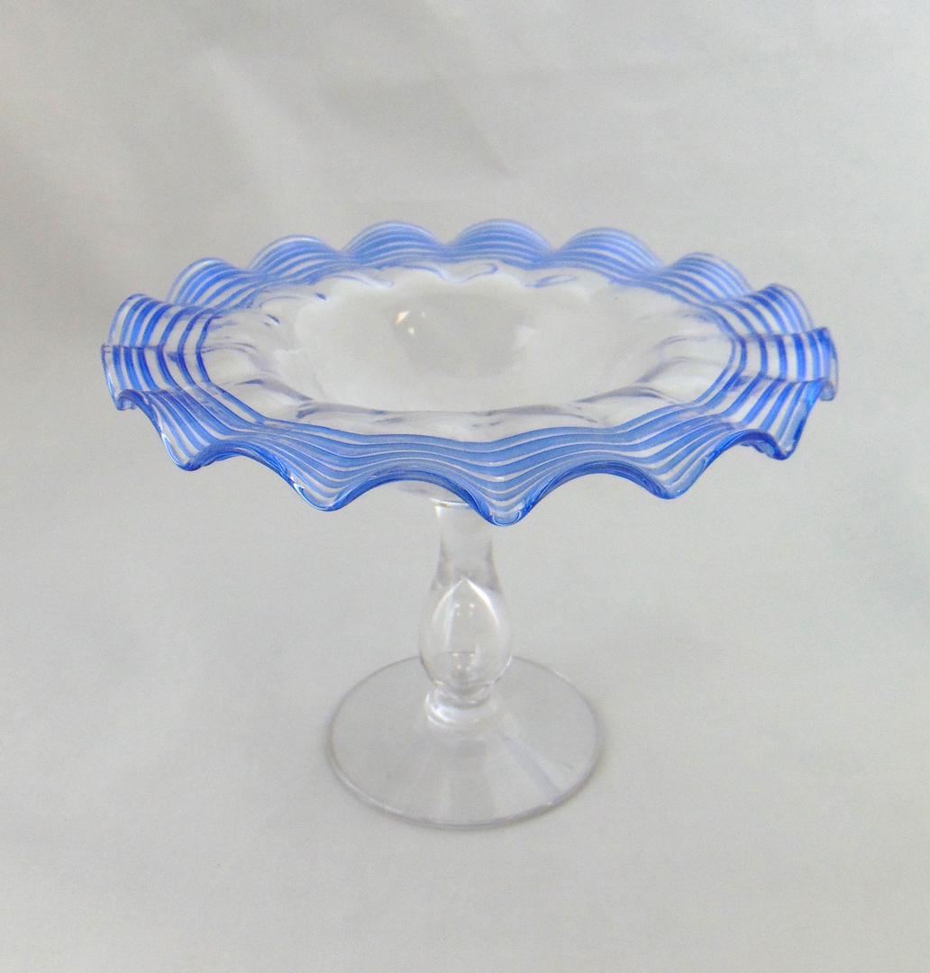 Steuben threaded glass compote: Footed ruffle rim compote with controlled blue threading, singed F Carder Steuben, 5" ht. Condition: good with no defects found