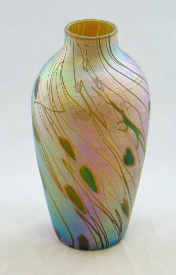 Steuben Millefiori glass vase: Shouldered form in platinum gold decorated with overall green hearts and vines and 18 white Millefiori, signed Aurene 596, 7 1/4" ht. Condition: good with no defects found.