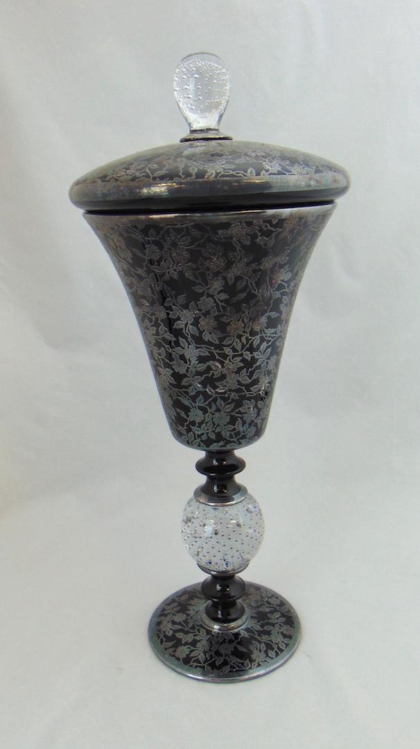 Pairpoint Silver Overlay glass Compote: Footed covered compote form glass vase in black glass decorated with a silver overlay leaf design, 15 1/2" ht. Condition: good with no defects found.