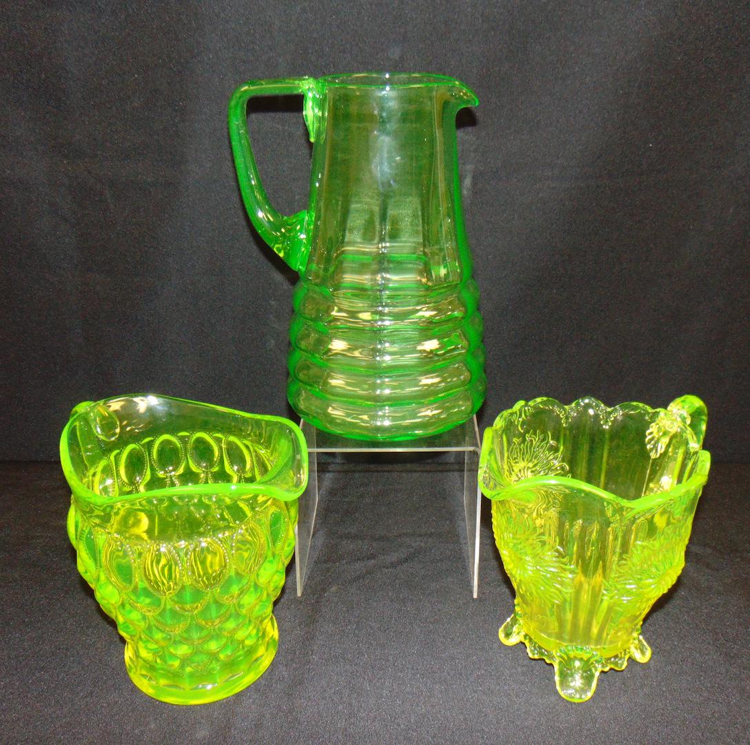 Three Vaseline glass water pitchers: Three large Vaseline water pitchers including a Mosser sun flower, 10 1/2" ht. Condition: good with no defects found.
