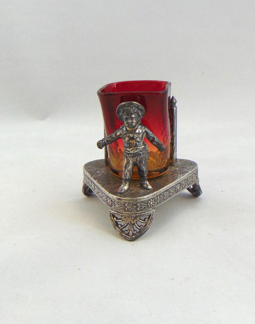 Amberina toothpick in holder: Optic diamond square mouth toothpick set in a Tuft Kate Greenway holder with a child, 3 1/2" ht. Condition: good with no defects found.