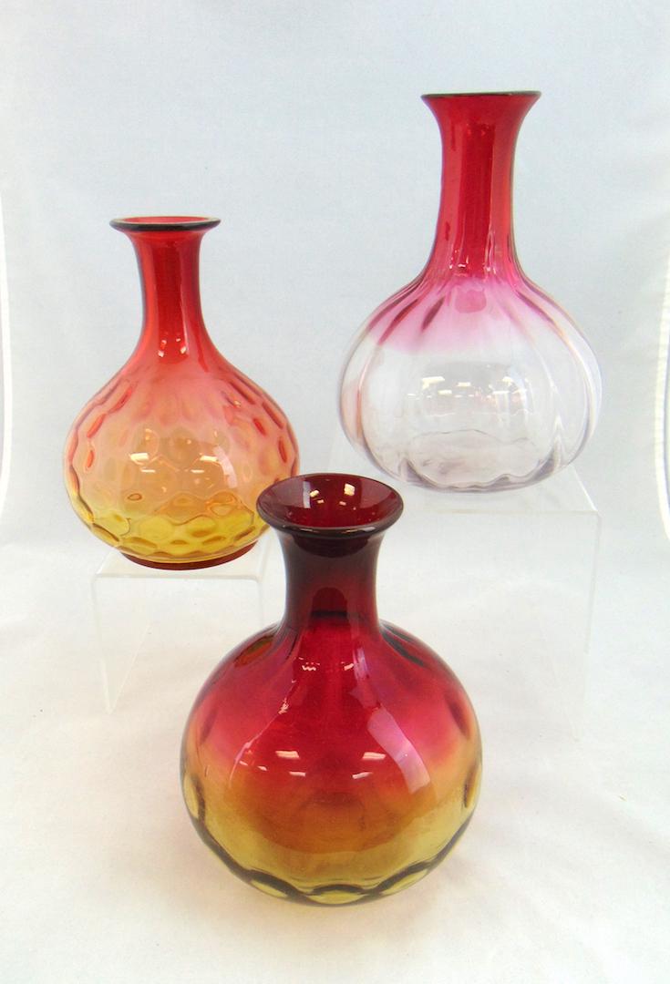 Three Art Glass bottle flasks,: Including one Rubina in an optic ribbed pattern, together with two Amberina in the coin spot paten, 7 3/4" ht. Condition: one with bump on the side..