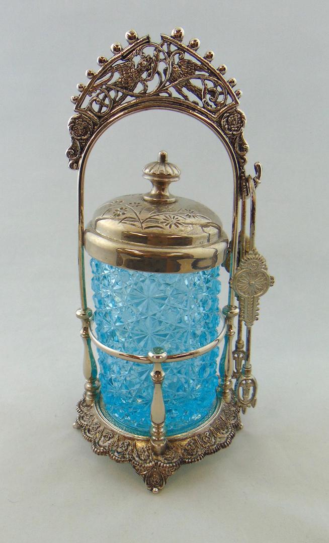 Blue daisy and button pickle castor: EAPG blue Daisy and Button pickle castor set in a scrolling and bird embossed caddy, 11" ht. Condition: good with no defects found.