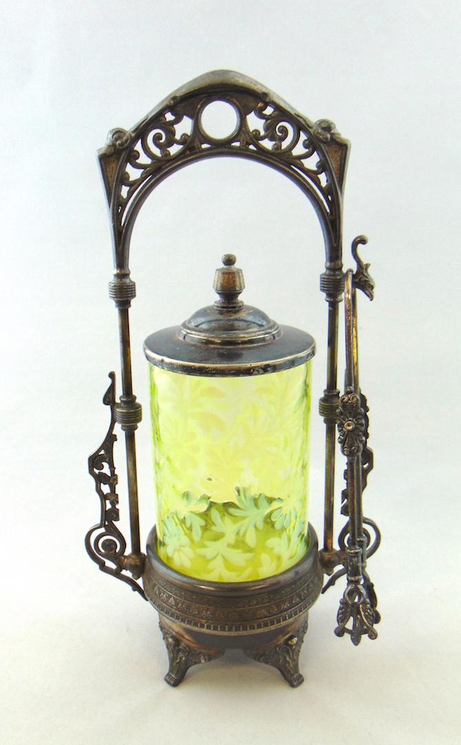 Daisy and Fern opalescent pickle castor: Vaseline opalescent glass pickle castor in the daisy and fern pattern set in a Webster silver-plate caddy, 12" ht. Condition: good with no defects found.