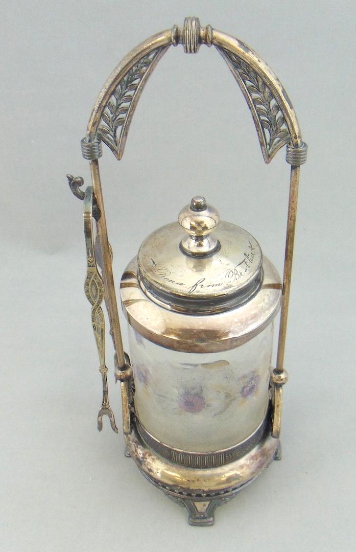 New England Pomona Pickle Caster: Cylindrical form in New England Pomona decorated with the corn flower pattern, set in a Meriden caddy, 11 3/4" ht. Condition: good with no defects found.