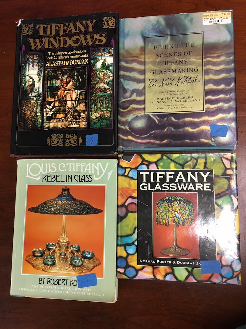 4 Books on Tiffany glass and lamps: Including "Tiffany Windows" by Alastair Duncan,"Tiffany Glassware" by Portor, "The Nash Handbook" by Eidelberg, and "Rebel In Glass" by Koch. All hardback. Condition: dust jacket wear.