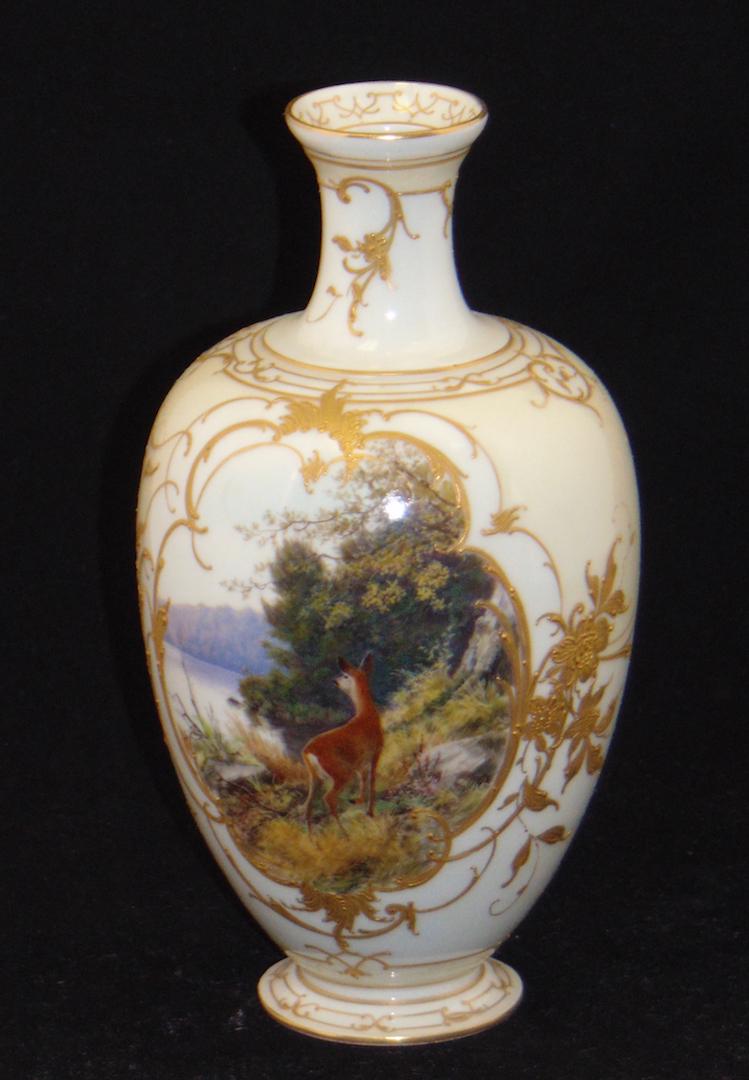 KPM porcelain urn form vase: KPM porcelain vase with gilt highlights framing a forest lake scene with deer, marked KPM, 8" ht. Condition: good with no defects found.