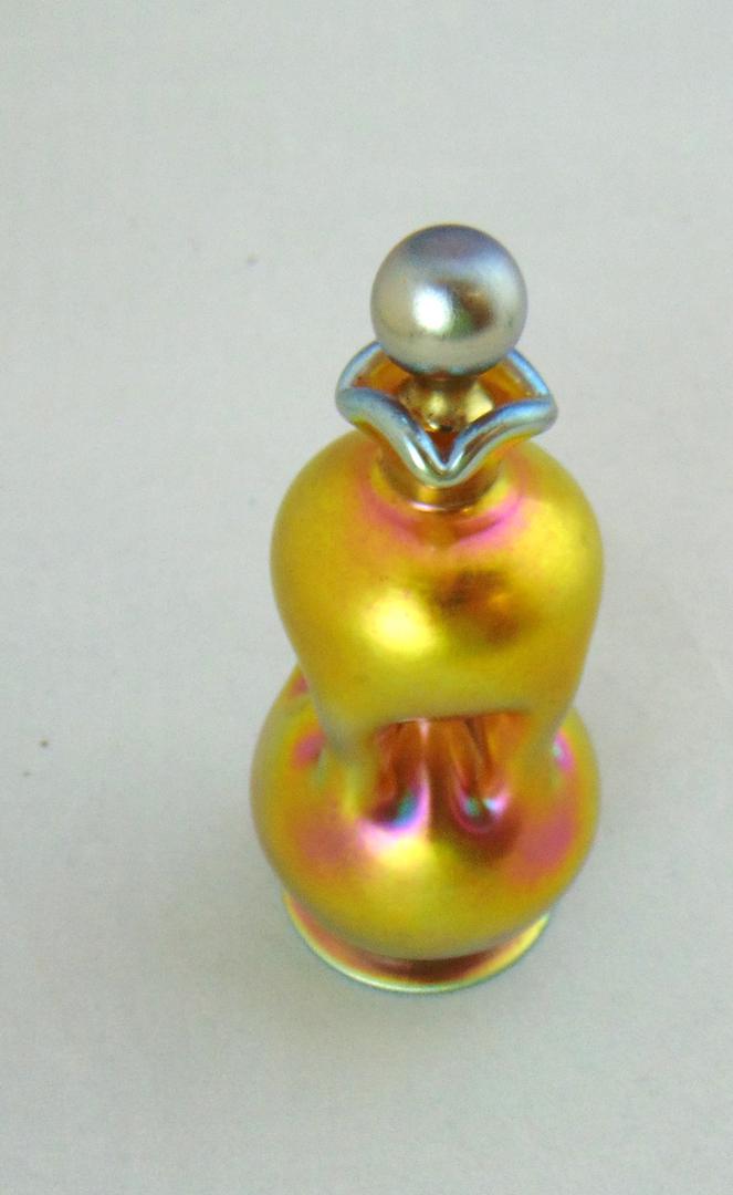 Steuben gold Aurene perfume bottles: Pinched sided gold Aurene perfume shape number 2834, signed Aurene, 4 1/2" ht. Condition: good with no defects found.