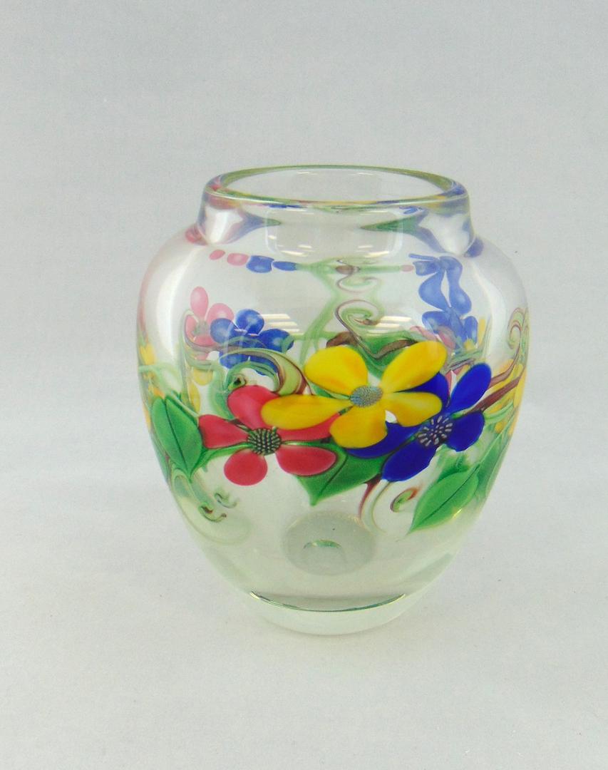 Orient Flume paperweight glass vase: Ovoid form in translucent glass decorated with a band of red, yellow and blue flowers on a green leafy vine, signed Orient and flume Braley, 6 1/4" ht. Condition: good with no defects found.