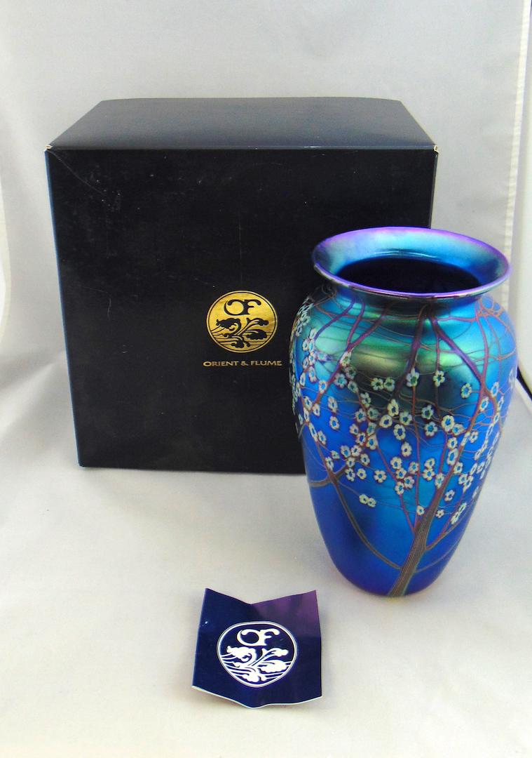 Orient and Flume Blue art glass vase: Shouldered form in iridescent blue glass decorated with brown trees of white Millefiori, comes with original gift box, signed Orient and Flume, 10" ht. PROVENANCE: Earlys Auction to the Black Collecti