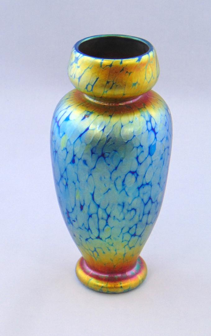 Lundberg art glass vase: Cylindrical shouldered form in mottled iridescent blue shading to gold in the Sunset dŽcor, 7" ht. Condition: good with no defects found.