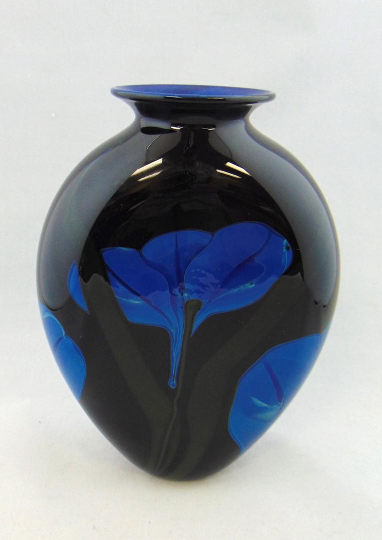 Rick Satava art glass vase: Flat sided black glass vase decorated with stemmed blue flowers, signed R Satava 0977-90, 9" ht. Condition: good with no defects found.