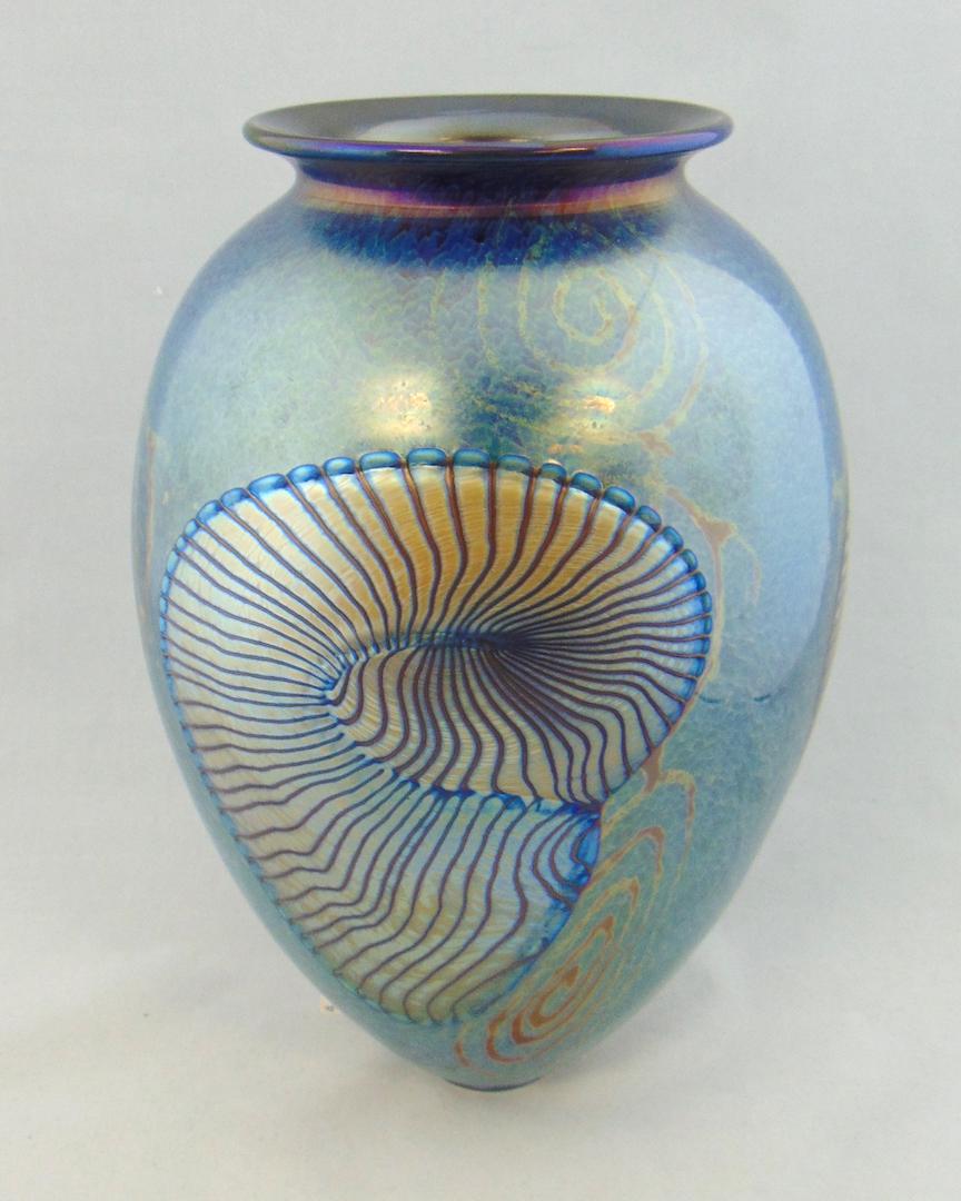 Rick Satava Conch Shell glass vase: Ovoid form in mottled blue decorated with a large gold Conch shell, signed Satava 1440-08, 11" ht. PROVENANCE: Earlys Auction to the Black collection. Condition: good with no defects found.