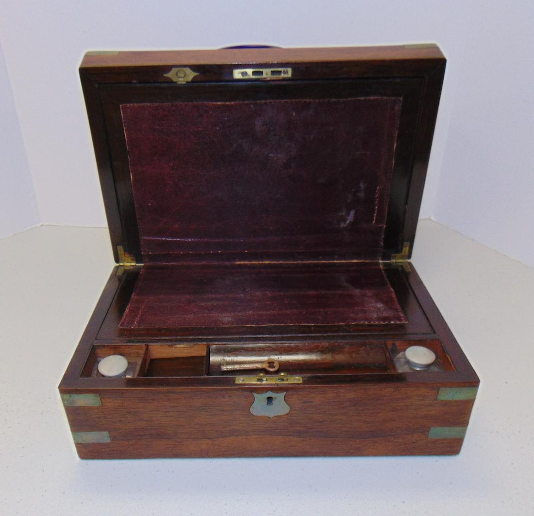 Antique lap writing desk: Circa 1850 lap writing desk with two ink bottles and working key, 14 by 9 by 5. Condition: box is good interior leather with cracks and wear, some wood wear on interior.