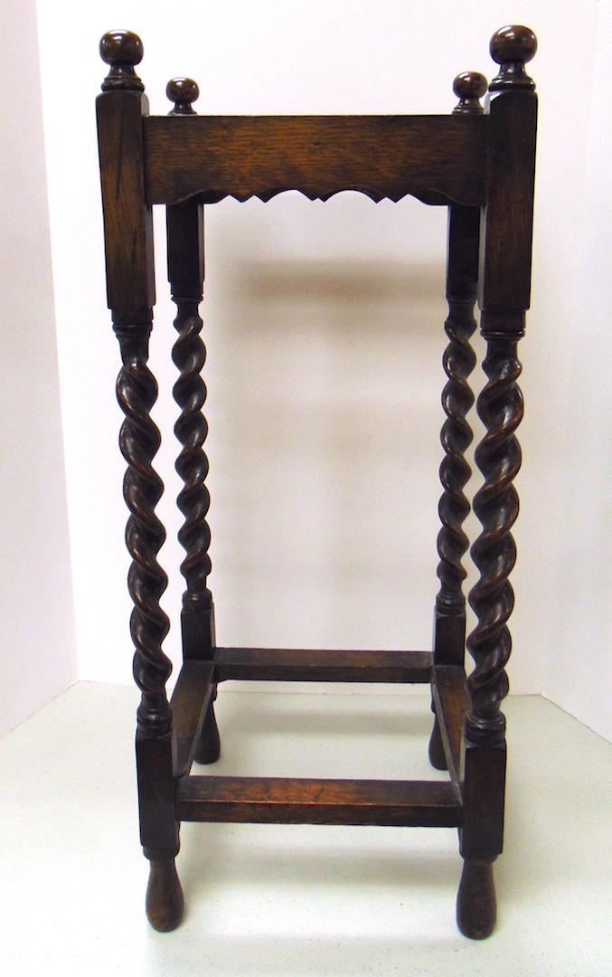 Antique Barley twist umbrella stand: Oak four sectional umbrella stand with barley twist legs and knob finials, has original metal tray, 29" ht. Condition: good, minor wear