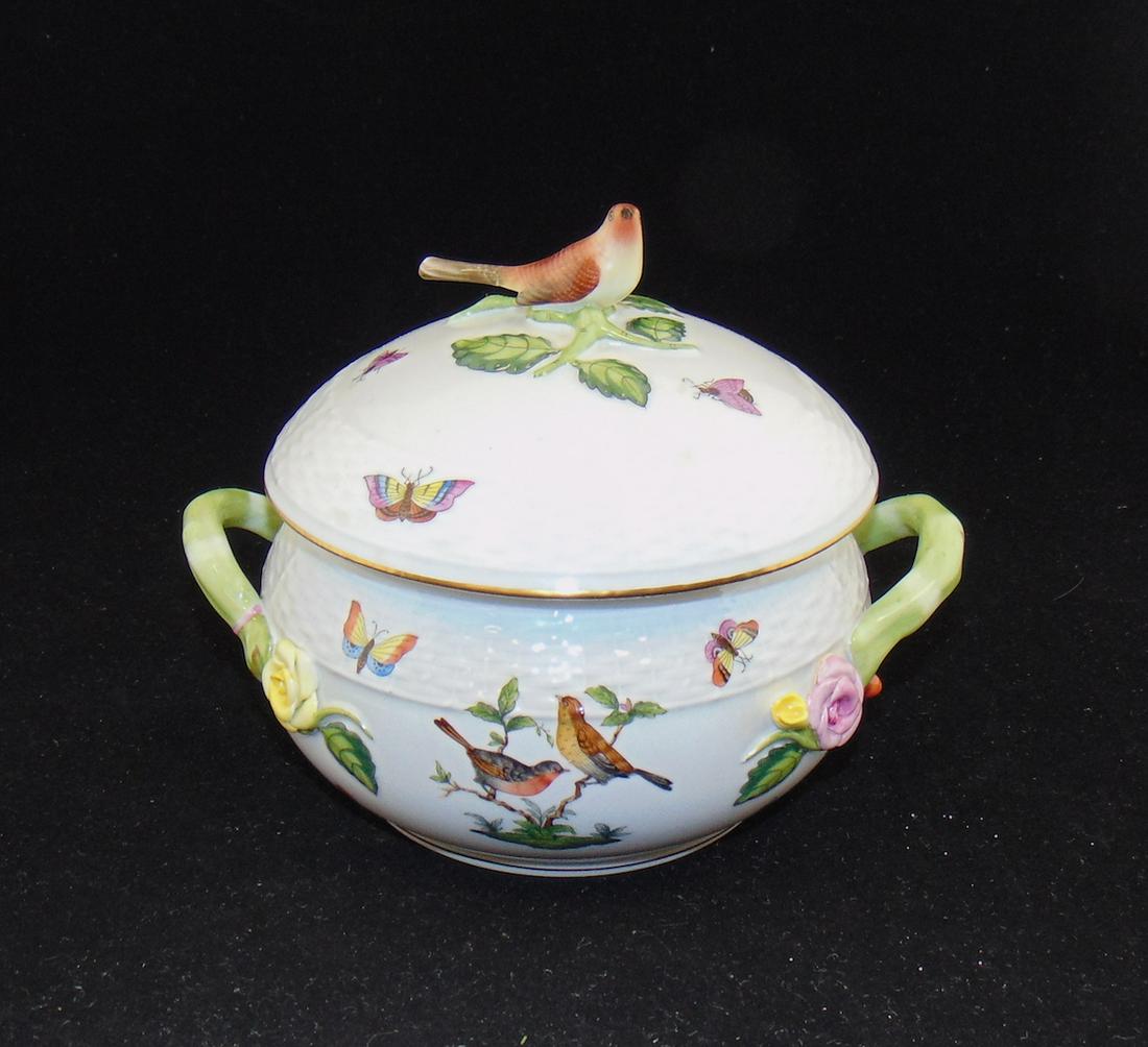 Herend porcelain covered casserole: Ovoid form in the Rothschild Bird pattern with side green handles and a bird finial, 7 3/4" wide. Condition: tail of the finial bird has been restored.