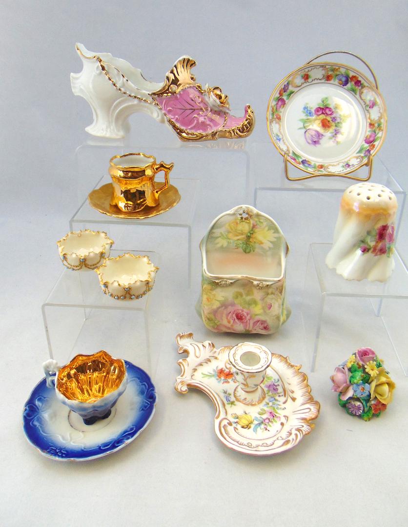 Group of porcelain items: Including a Dresden candle stick, a Royal Bayreuth wall match holder, two Willets Belleek open salts, a Meissen finial and more. Largest shoe 6 1/2" long. Condition: chips to both diminutive cups.