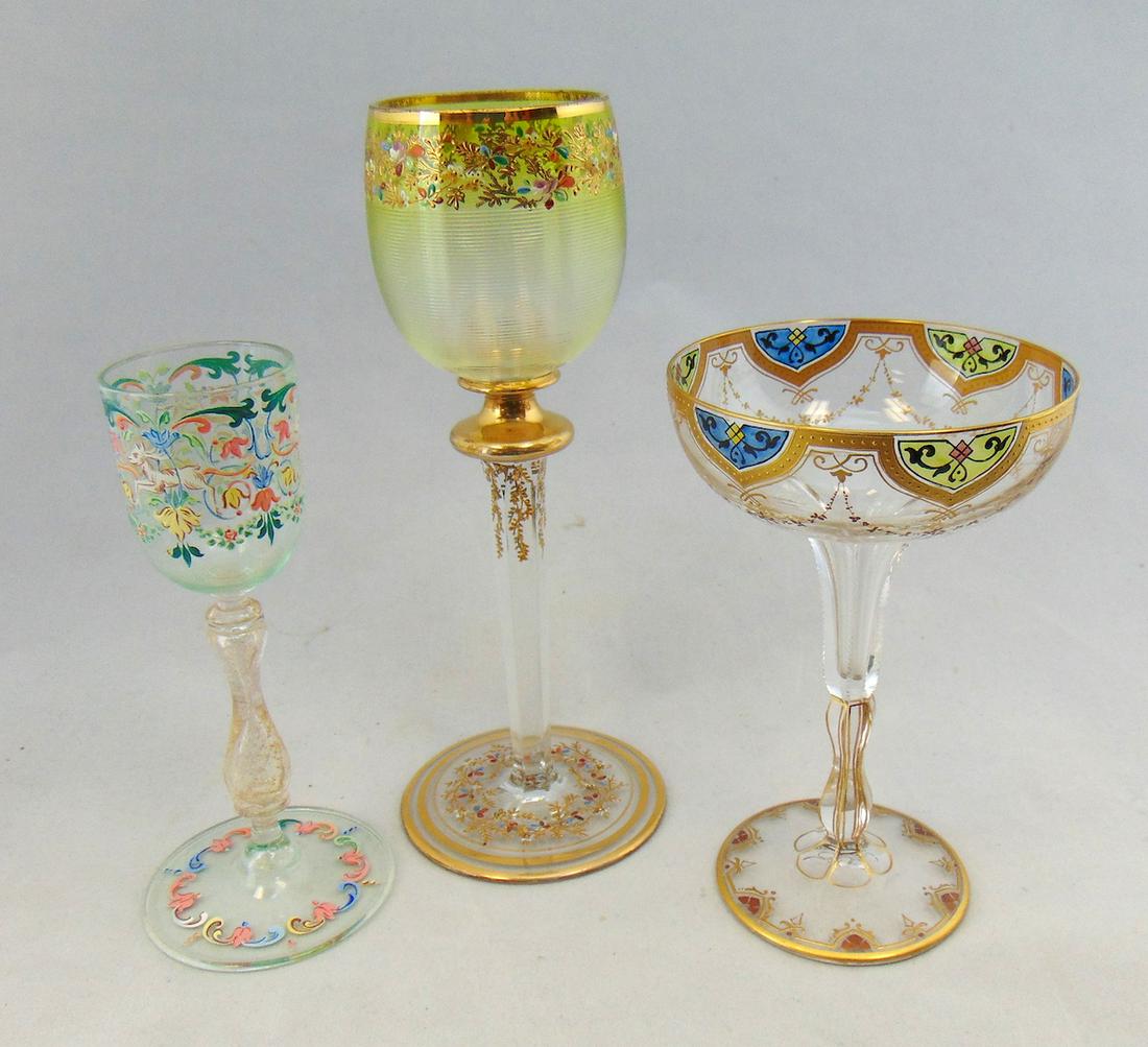 Three vintage glass goblets: Including Moser with controlled threading and dainty polychrome flowers, a Salviati diminutive goblet with deer, and a faceted stem goblet with translucent panels framed in gold attributed to Moser, 8
