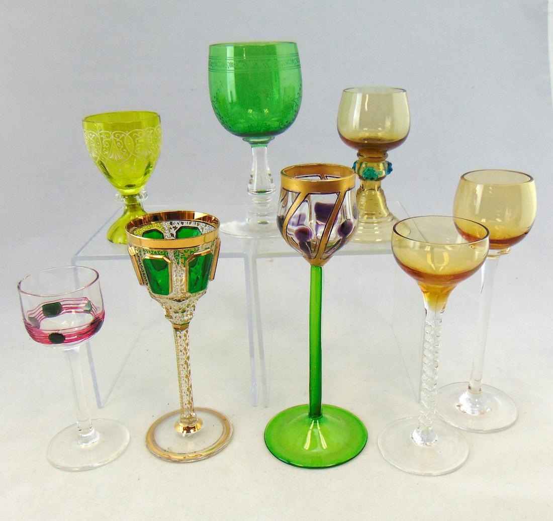 Group of eight glass cordials: Including a Harrach amber with Prussian blue prunts, two Poschinger with marquetry and applique, a green Listovane and more. LITERATURE: on the Poschinger see "Das Bohmische Glas" page 56. Condition: 