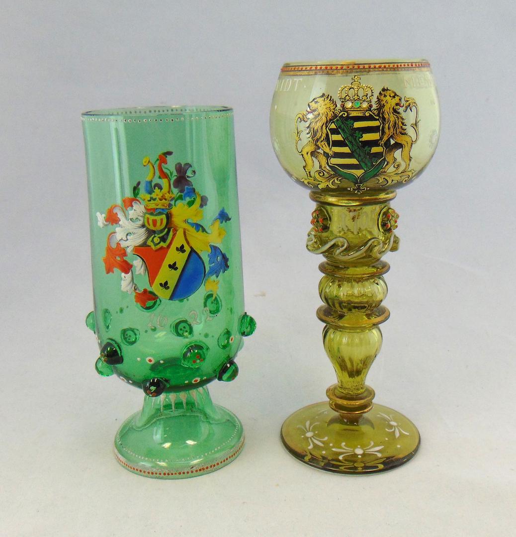 Two Bohemian glass goblets: Neuwelt green Romer with herald shield of two rampant lions and date 1705, together with footed tumbler with shield and date 1622, tallest 7 1/2' ht. Condition: good with no defects found.