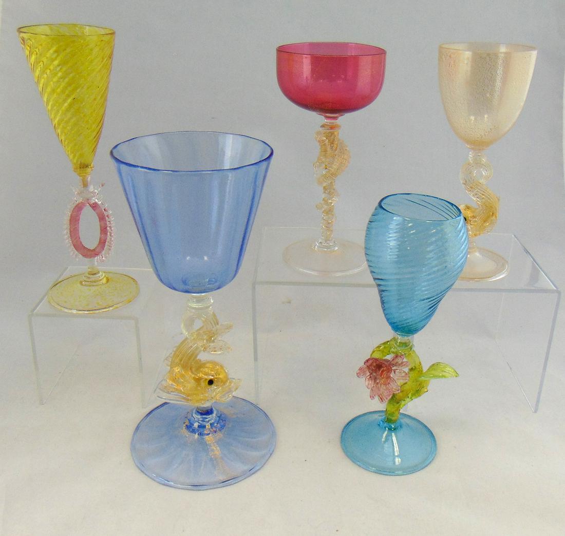 Five Venetian figural glass goblets: Including a blue and gold fleck dolphin, cranberry with stemmed sea horse, a canary yellow with crimson oval standard, and a Prussian blue with red flower, tallest 8" ht. Condition: good with no defec