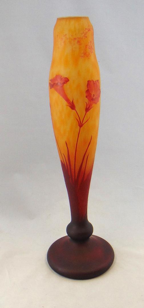 Tall Wheel carved Daum Nancy vase: Footed cylindrical form in mottled yellow and orange decorated with 6 tall stemmed wheel carved red flowers in various stages of bloom, engraved Daum Nancy, 18 1/2' ht. Condition: good with no defects