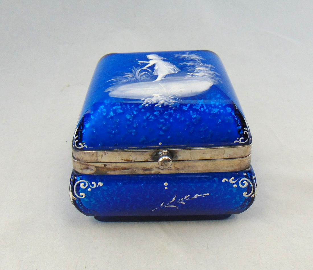 Magnificent Mary Gregory dresser box: Rectangular form in blue glass with silver aventurine decorated with a young girl picking flowers, 4 1/2" side by 3 1/2" ht. Condition: glass is good, one lid chain broke.