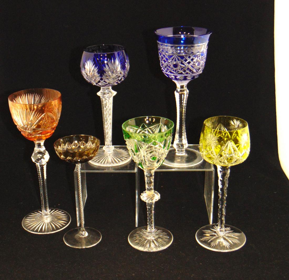 Six cut to clear glass goblets: Including a green Baccarat, two cobalt, one lime, one Peach and an amber cordial each with faceted or swirled stems, tallest 8 1/2" ht. Condition: small chip to one blue, dis coloration to the knop of
