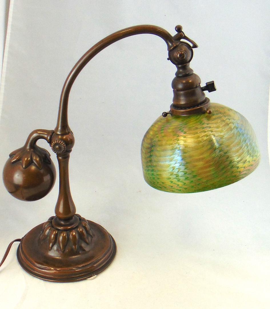Tiffany Damascene desk lamp: Tiffany counter-balance bronze and glass desk lamp. Bronze base with reddish brown patina with an adjustable socket signed Tiffany Studios New York carries a green Favrile undulating shade signed L C