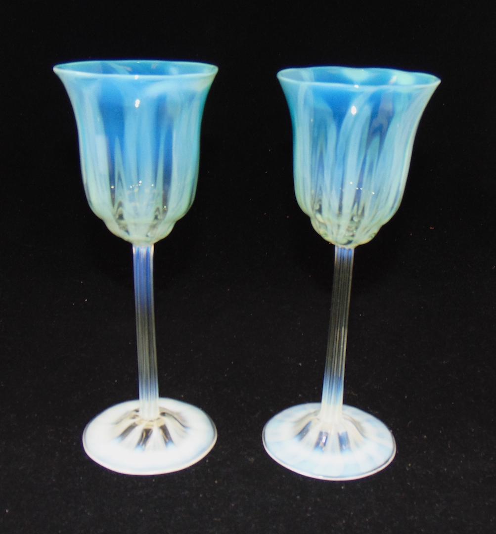 Two Tiffany green pastel goblets: Opalescent footed goblet with reeded standard rises to a green opalescent pastel goblet, each signed L C Tiffany Favrile, 8" ht. Condition: good with no defects found.