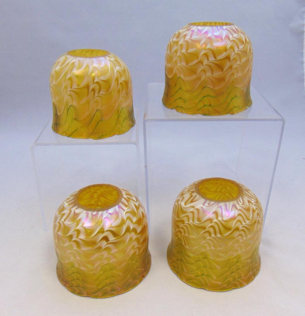 Group of Four iridescent shades: Dome form in iridescent gold decorated with a green undulating band graduating to white, 3" ht. LITERATURE: see Collection Art Nouveau Shades by Roberts page 70 number 286 were he attributes to Durand