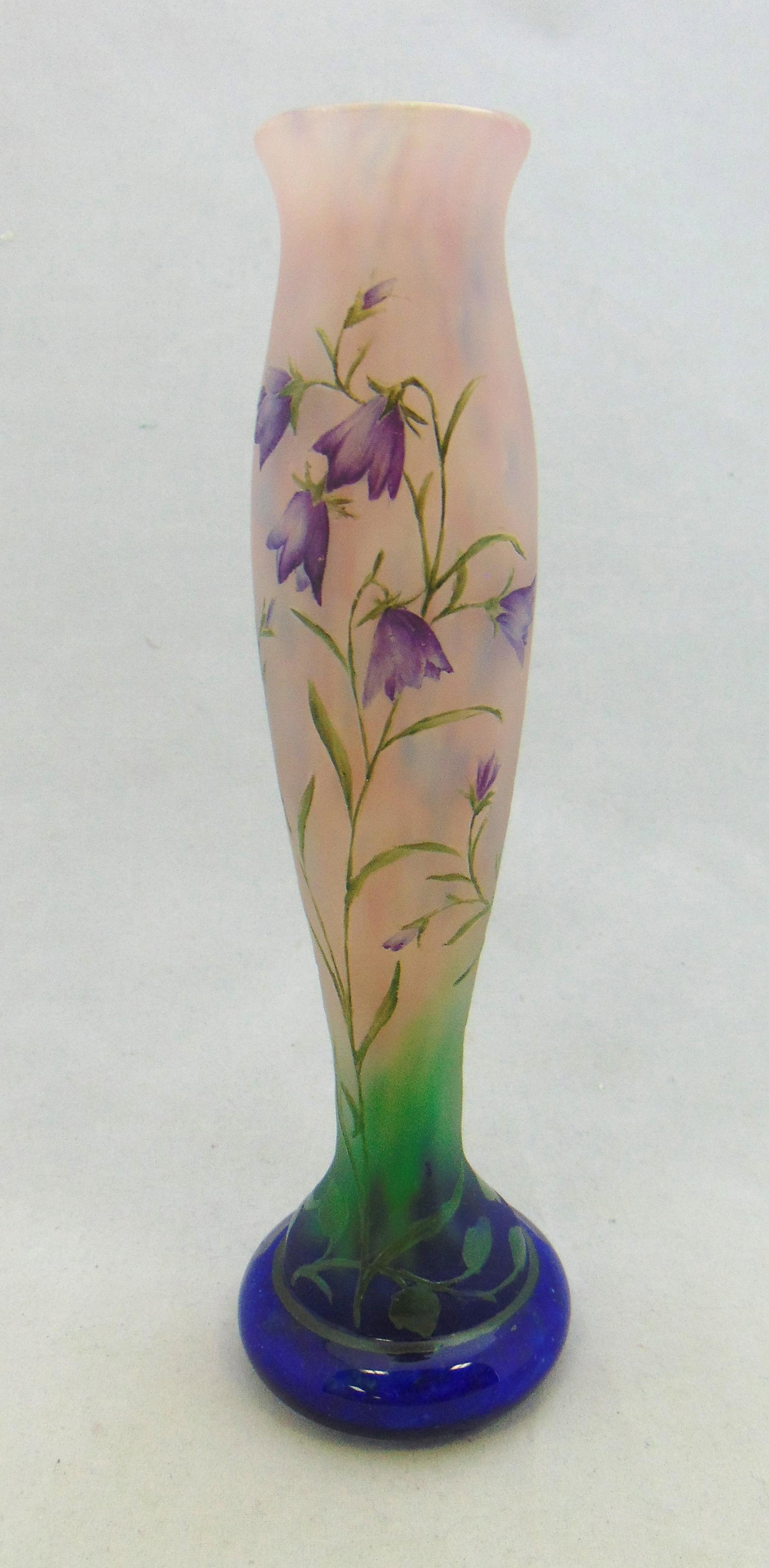 Daum Nancy cameo glass vase: Daum Nancy cylindrical form glass vase in blue to pink decorated with green stemmed purple flowers, 7 3/4' ht. Condition: good with no defects found.