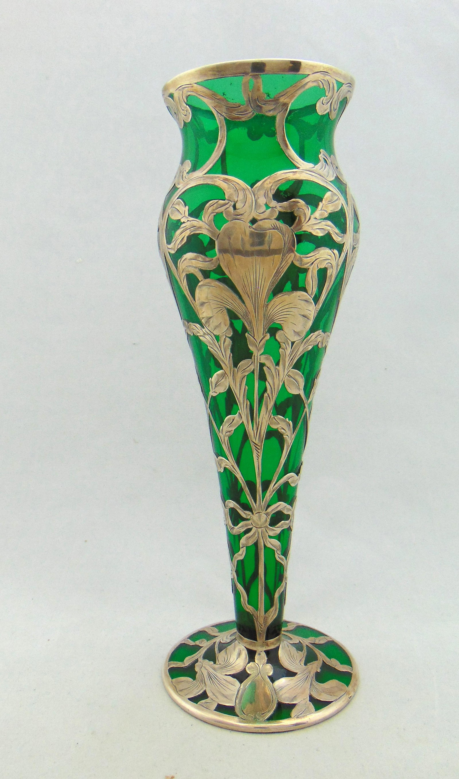 Silver overlay green trumpet vase: Footed green trumpet vase with a scrolling silver overlay of stemmed flowers, silver marked M 533, 10 1/4" ht. Condition: good with no defects found.