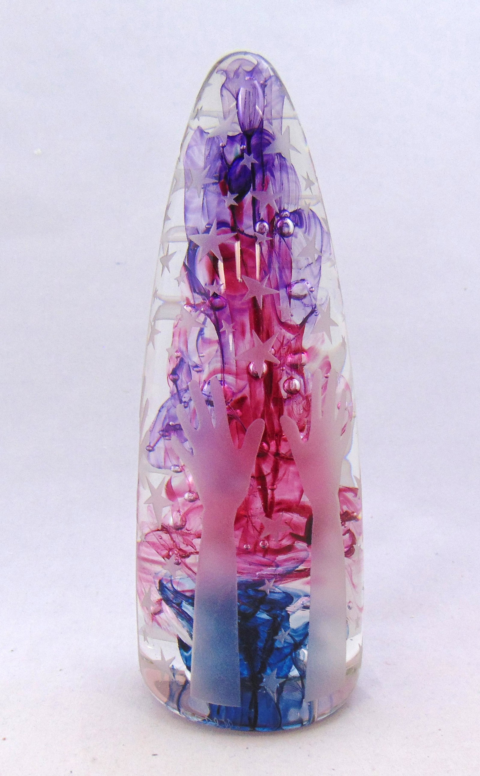 Duncan McClellan art glass sculpture: Titled "Reaching for the stars" bullet form in translucent glass with wisp of red purple and blue decorated with acid cut hands and stars, signed McClellan, 7 1/2' ht. Condition: good with no defects