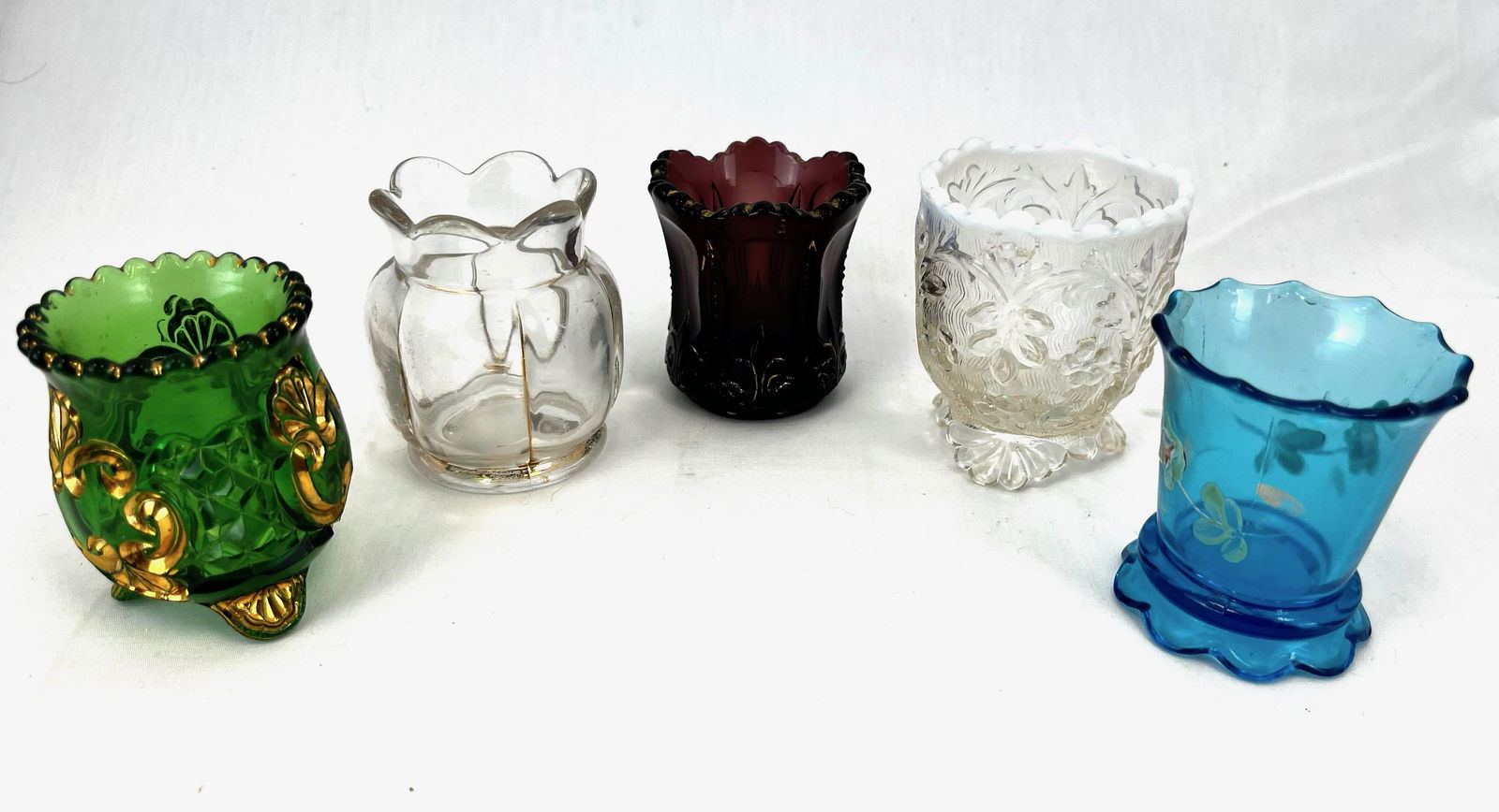 Five vintage glass toothpick holders: Five vintage glass toothpick holders including a Scalloped Skirt, Croesus, Flora, X ray, and Iris Meander, tallest 3 1/2" ht. Condition: good, with minor wear.