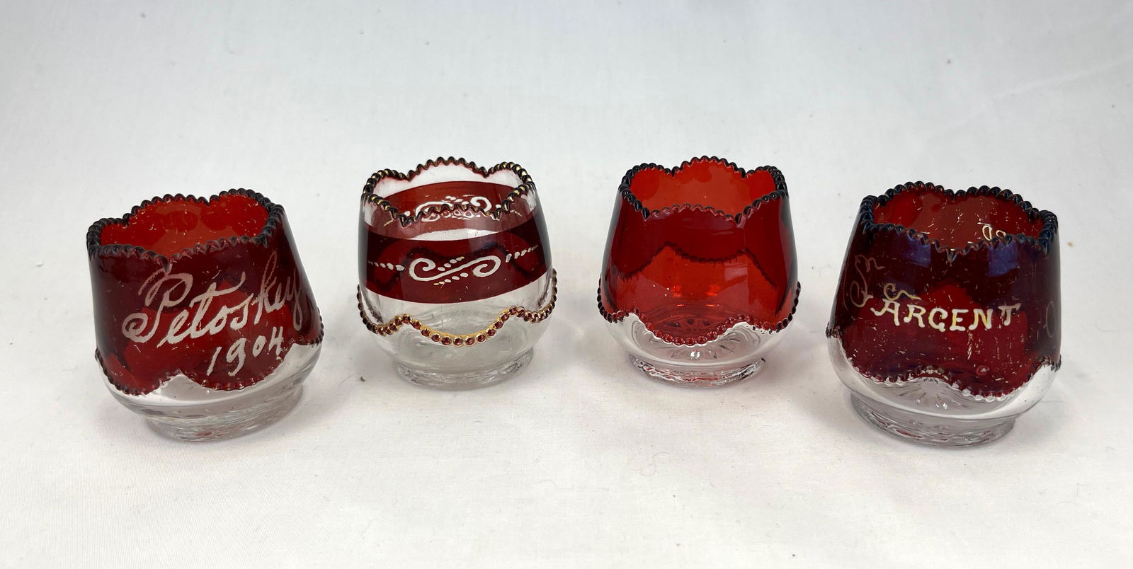 Four Heisey Bead Swag toothpicks: Four Souvenir Heisey Bead Swag, ruby flashed toothpick holders; 2 1/8" ht.; Literature: Bredehofts/the Sanfords - Glass Toothpick Holders, Second Edition, p. 91. CONDITION: good with minor wear.