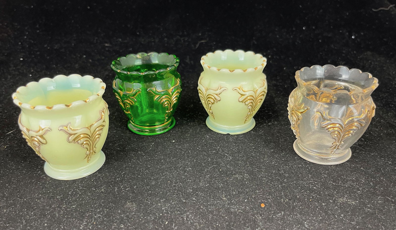 Four Heisey Winged Scroll toothpicks: Four Heisey Winged Scroll with gold dŽcor toothpick holders including two opal, one clear, and one green; 2 148" ht.; Literature: Bredehofts/the Sanfords - Glass Toothpick Holders, Second Edition, p.