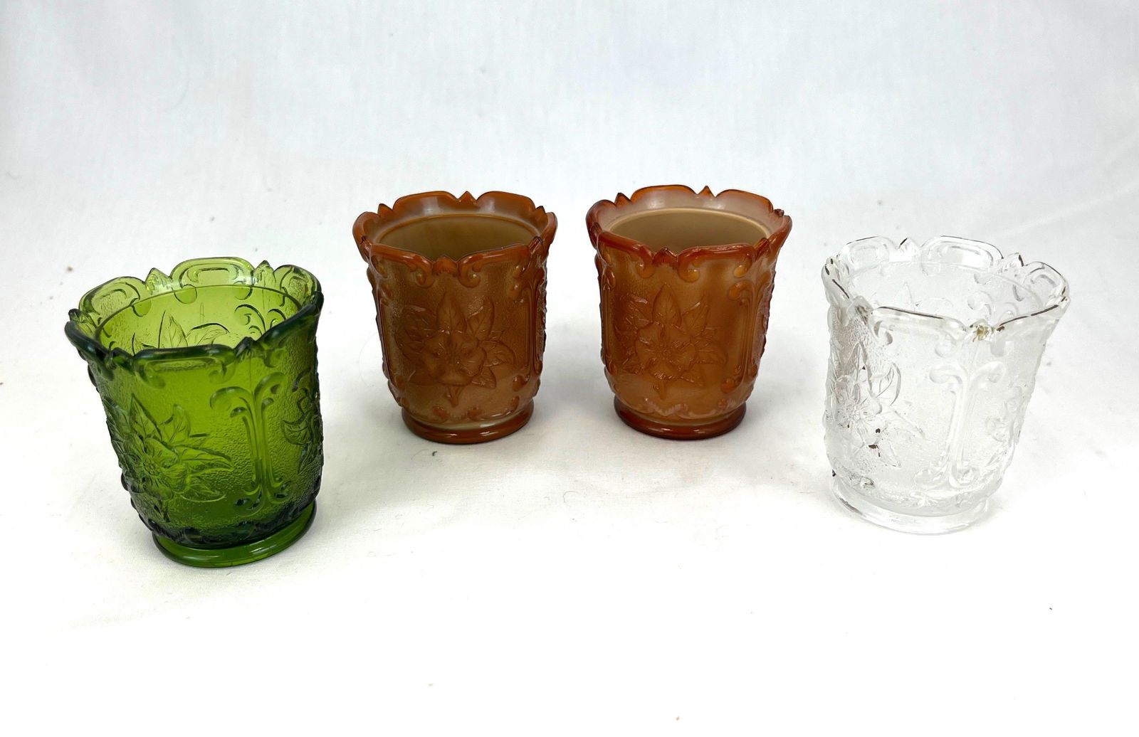 Four Sultan toothpick holders: Four National Glass Co (Wildrose with Scrolling) Sultan toothpick holders, including two chocolate, one clear, one emerald green; 2 1/4" ht. Literature: Bredehofts/the Sanfords - Glass Toothpick Holde