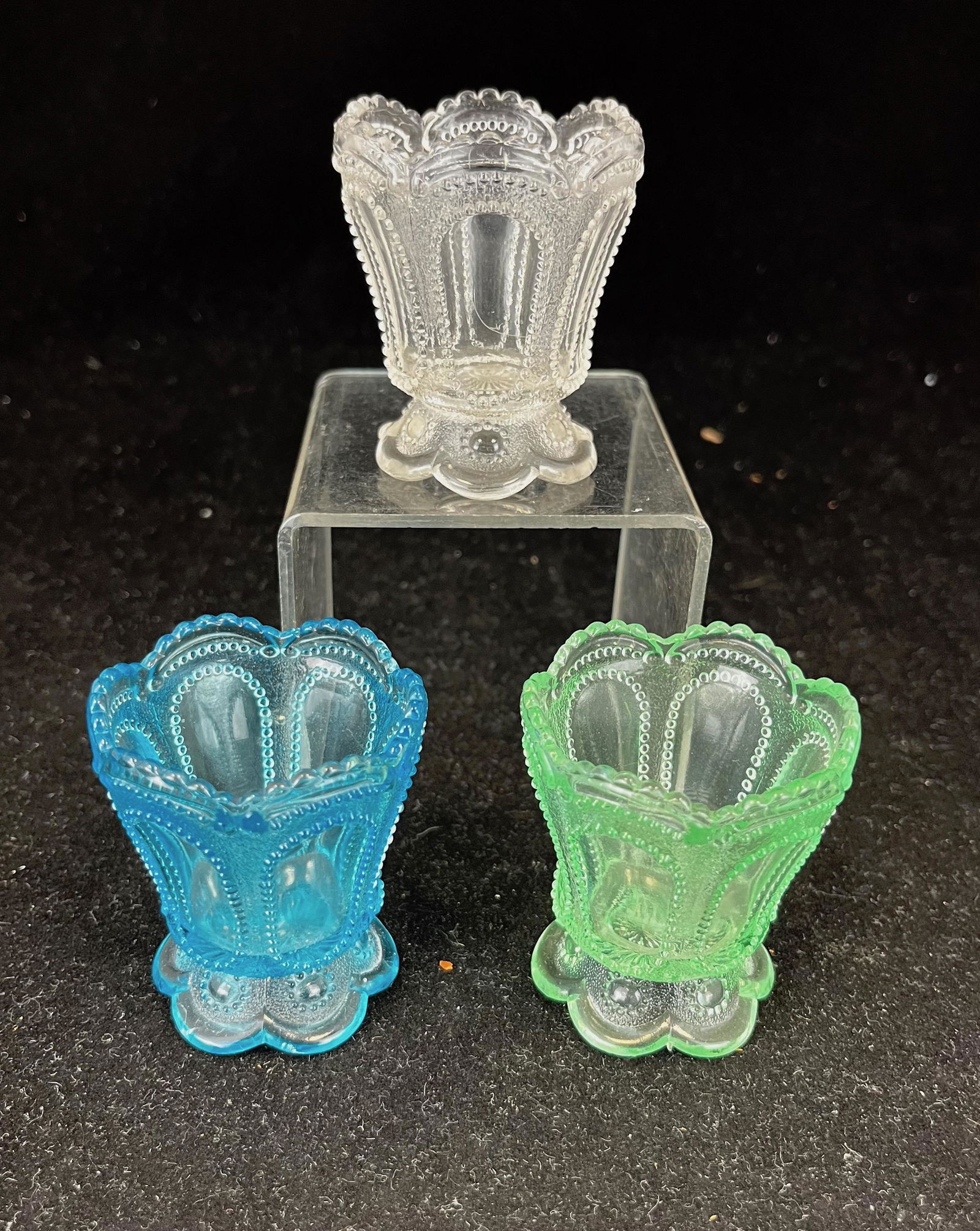 Three Beaded Ovals in Sand toothpick: Three Dugan Beaded Ovals in Sand toothpick holders including a green, a glue, and a clear; 2 3//8" ht. Literature: Bredehofts/the Sanfords - Glass Toothpick Holders, Second Edition, U.S. Glass Co p. 6