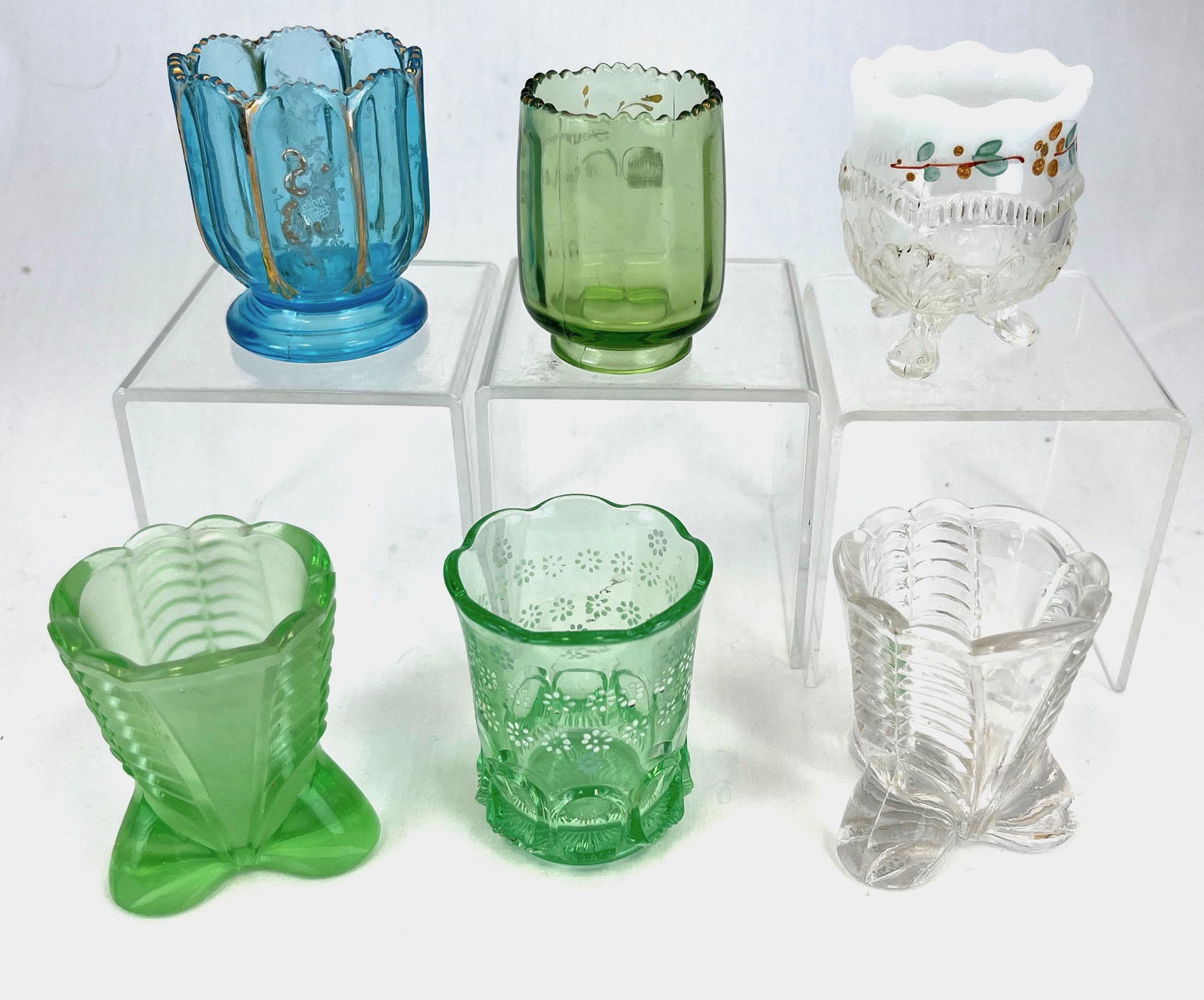 Group of six EAPG toothpick holders: Group of six EAPG toothpick holders various makers and colors, patterns include Ribbed Thumbprint, Nestor with enameling, Jefferson Optic, two Polished Plumes, and Wreath & Scroll; tallest 2 3/8". CON