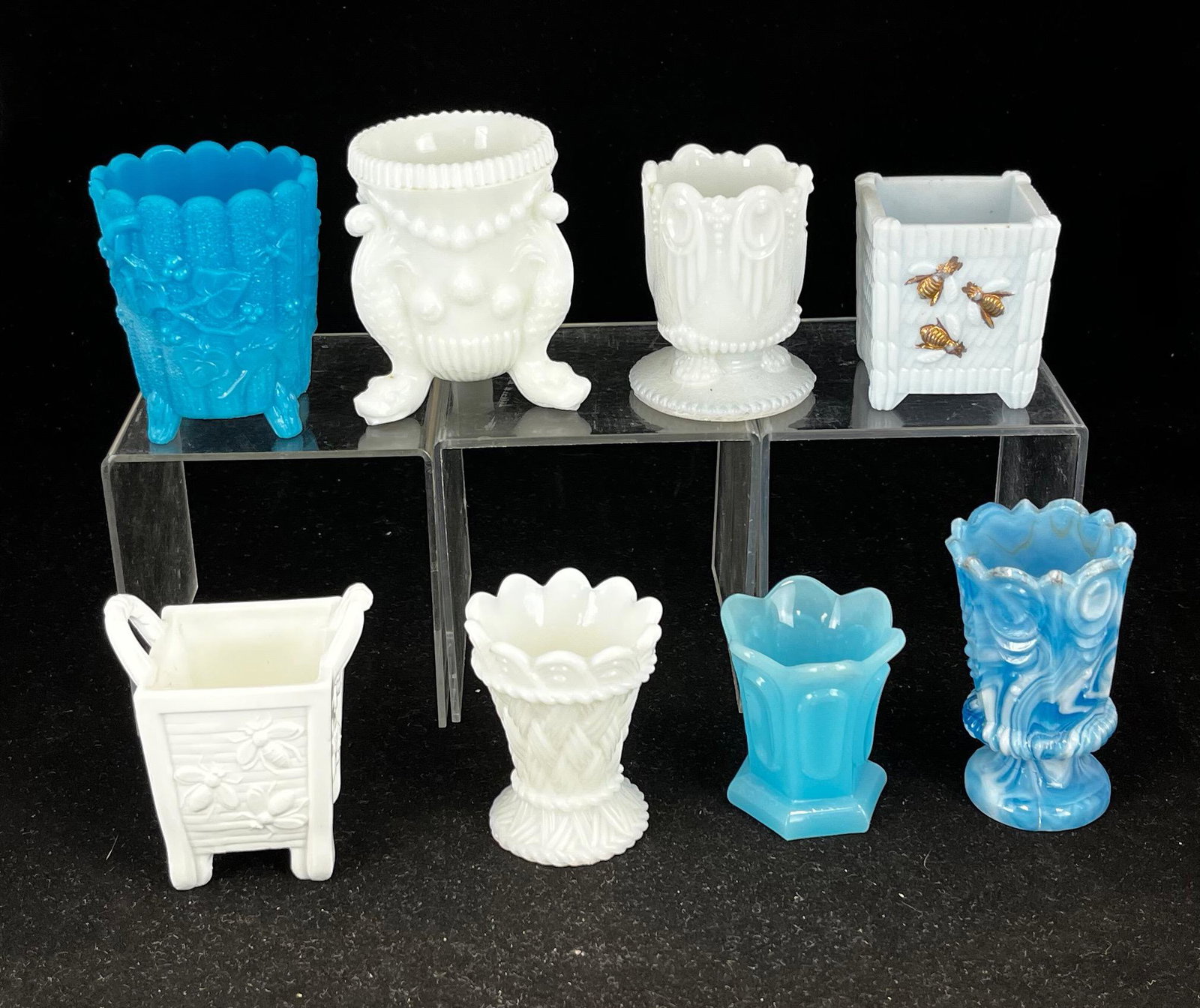 Group of eight milk glass toothpicks: Grouping of eight milk glass toothpicks, various makers, patterns include a white Wicker, a blue Ivy, two Bees on Basket one white, one light blue with enameling, a blue Framed Ovals, and a white Razz