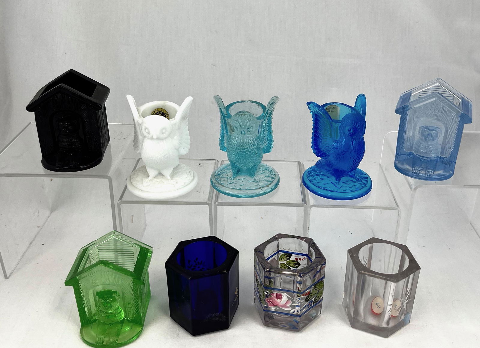 Nine Westmoreland toothpick holders: Nine Westmoreland toothpick holders various patterns and colors including a clear Colonial, a blue with enameled flowers, and a clear with enameled flowers, a green, blue , and a black Dog House, a mi