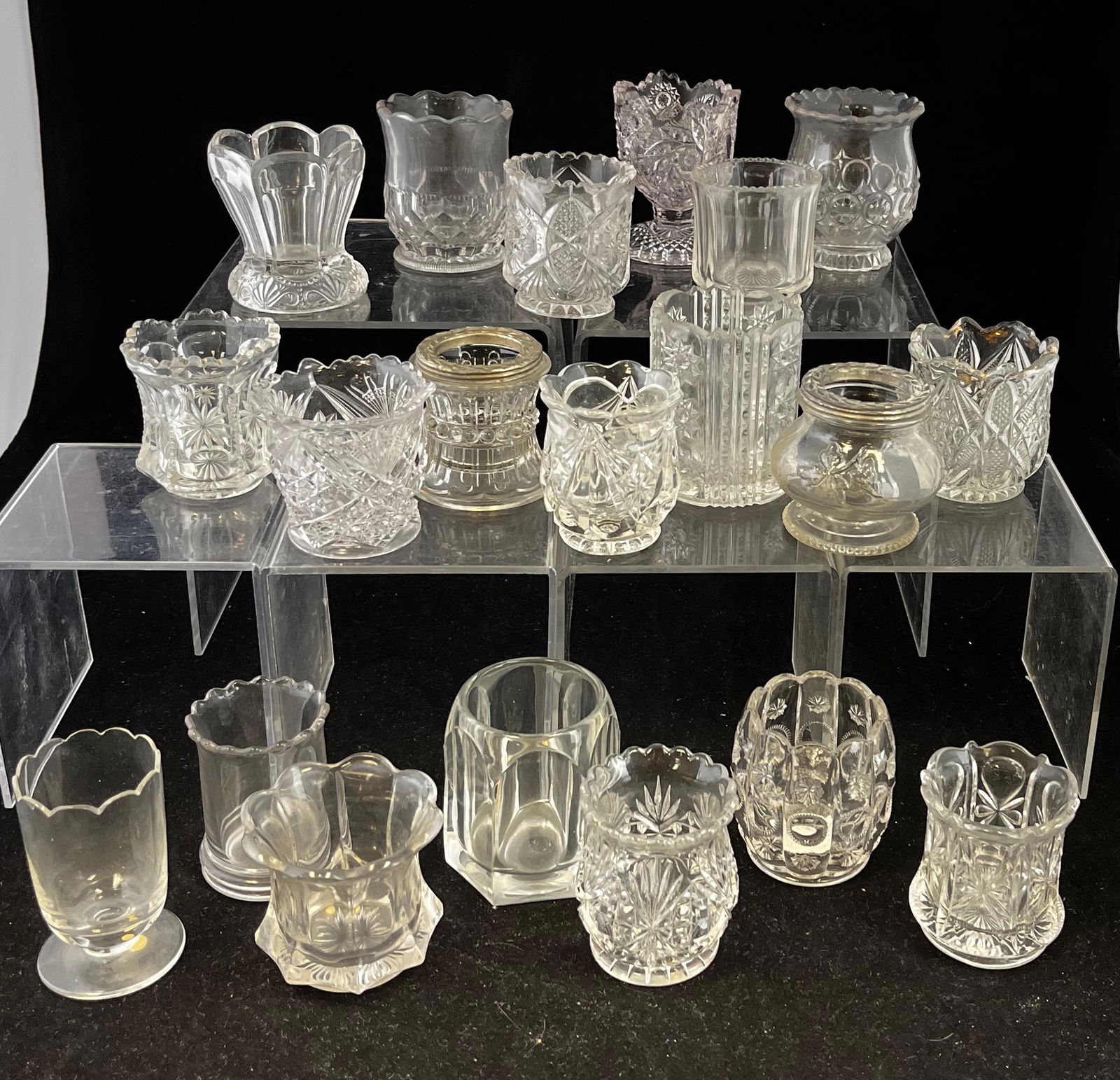 20 EAPG clear assorted toothpicks: 20 assorted EAPG clear toothpick holders various makers and patterns; tallest 2 3/4". CONDITION: good with minor wear.