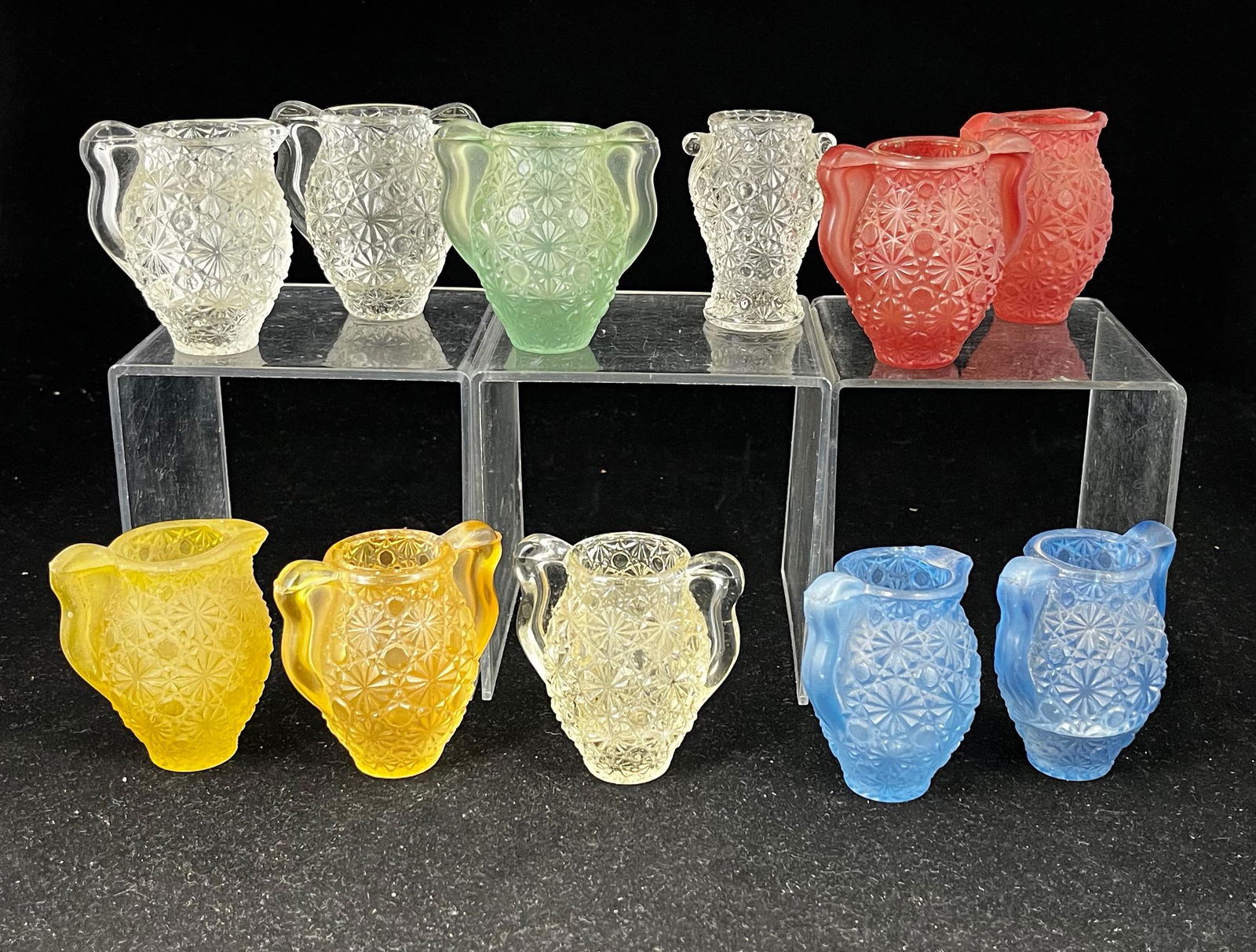 Group of 11 Daisy & Button toothpicks: Group of 11 early 20th century Daisy & Button toothpick holders, various pastel colors frosted and clear and styles including two handled urns and pitchers; 2.5". CONDITION: no significant defects fou