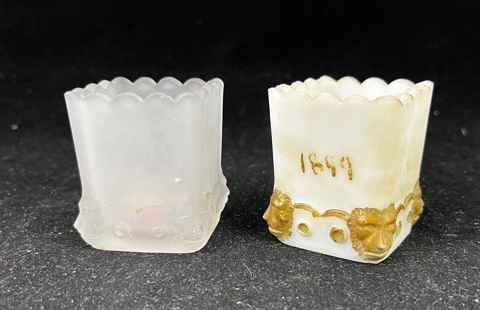 Two Fostoria Lion (Atlanta) toothpicks: Two Fostoria Lion (Atlanta) toothpick holders one clear frosted, one milk glass with gold dŽcor; 2" ht. Literature: Bredehofts/the Sanfords - Glass Toothpick Holders, Second Edition, p. 78. CONDITION