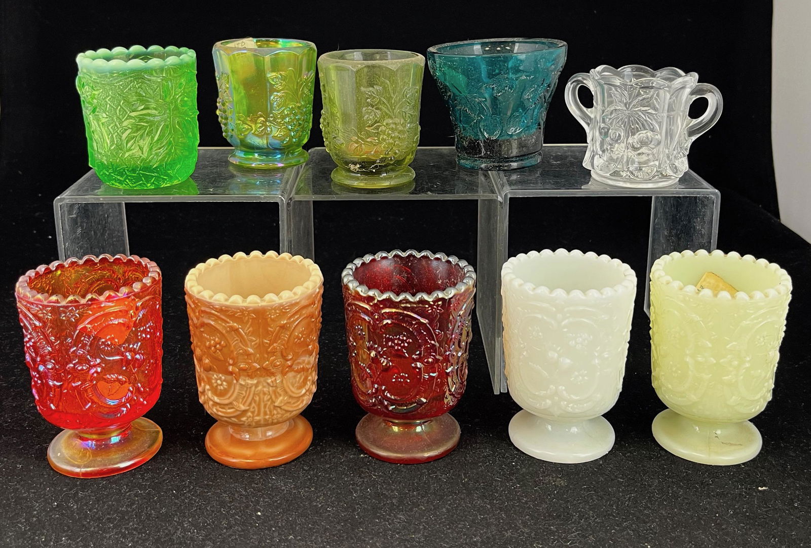 Group of 10 contemporary toothpicks: Group of 10 Fenton and other contemporary toothpick holders of various patterns and colors including Wreathed Cherries in chocolate, custard, milk glass, and iridescent amber and orange; a green Maple