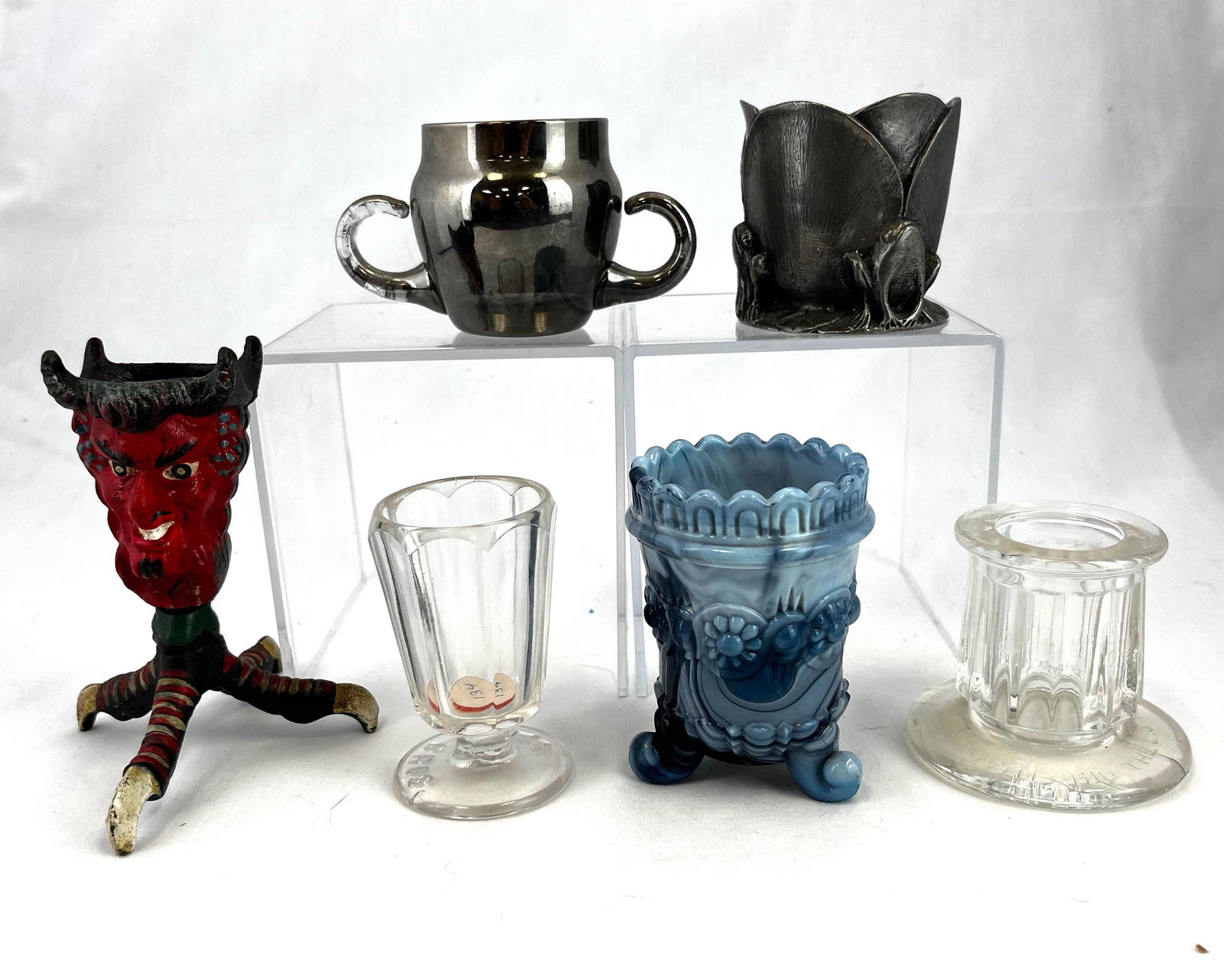 Group of six assorted toothpick holders: Group of six assorted toothpick holders, various makers, patterns, material, and colors including a Wrought Iron Devil, a pewter NTHCS, a mercury two handle, two clear advertising, and a blue Agata; t