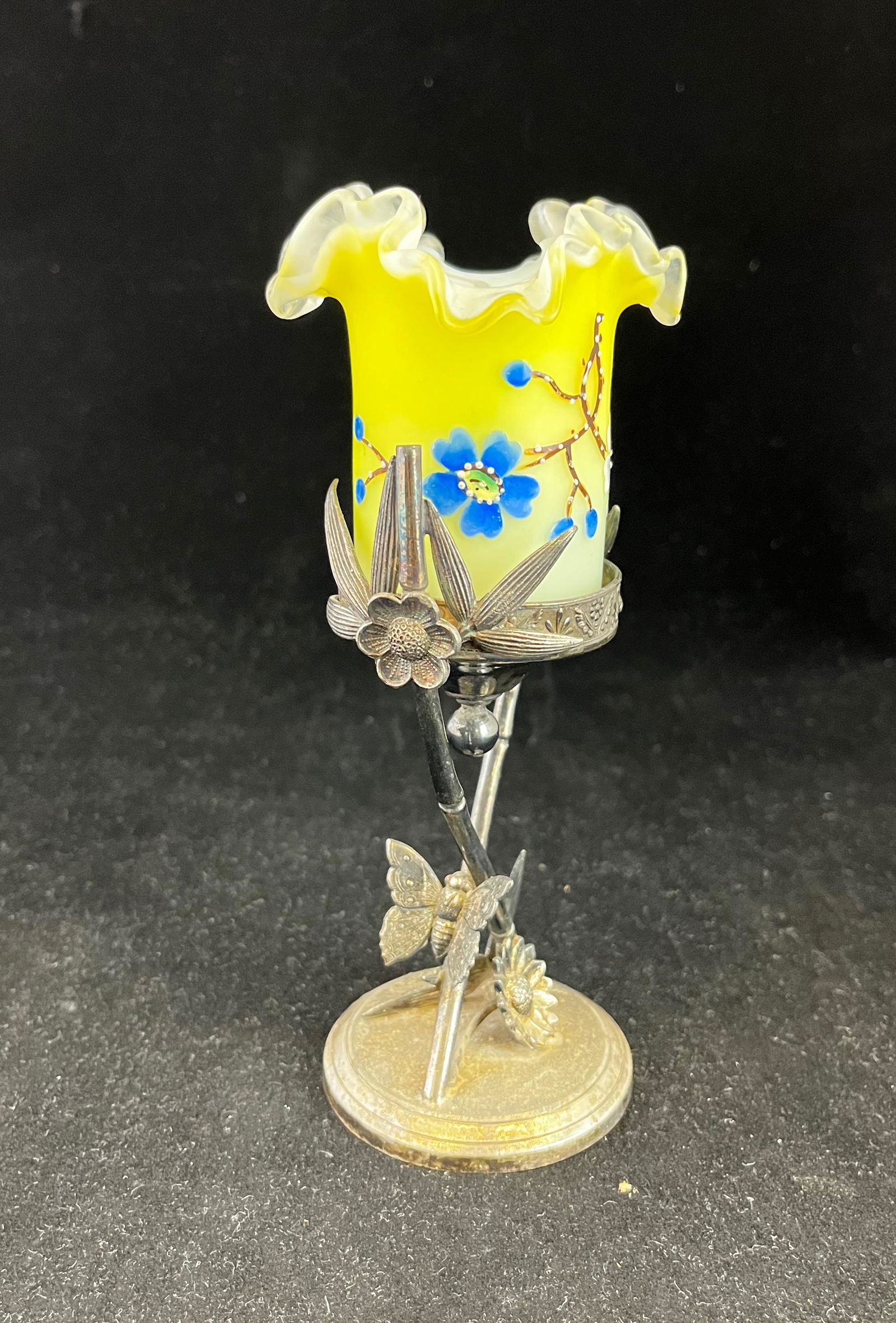 Glass and metal toothpick holder: Yellow satin glass toothpick holder with ruffled rim, decorated with enameled Dogwood Flower set in a butterfly embossed Tufts stand; 7" ht. CONDITION: good with no defects found.
