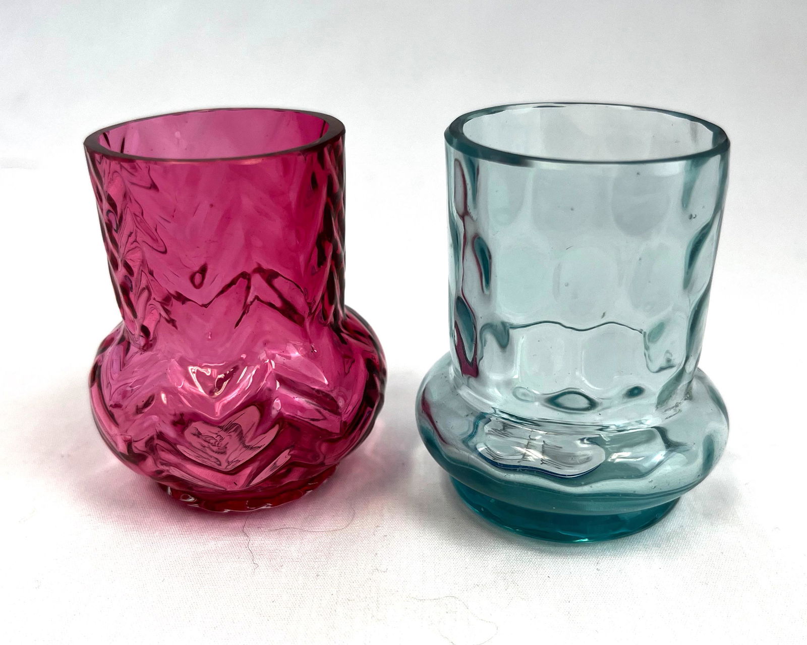 Two Phoenix toothpicks: Two Phoenix toothpick holders including a ruby Herringbone together with a blue Thumbprint; 2 1/4" ht. CONDITION: good with very slight roughness to one spot on interior rim of Thumbprint.