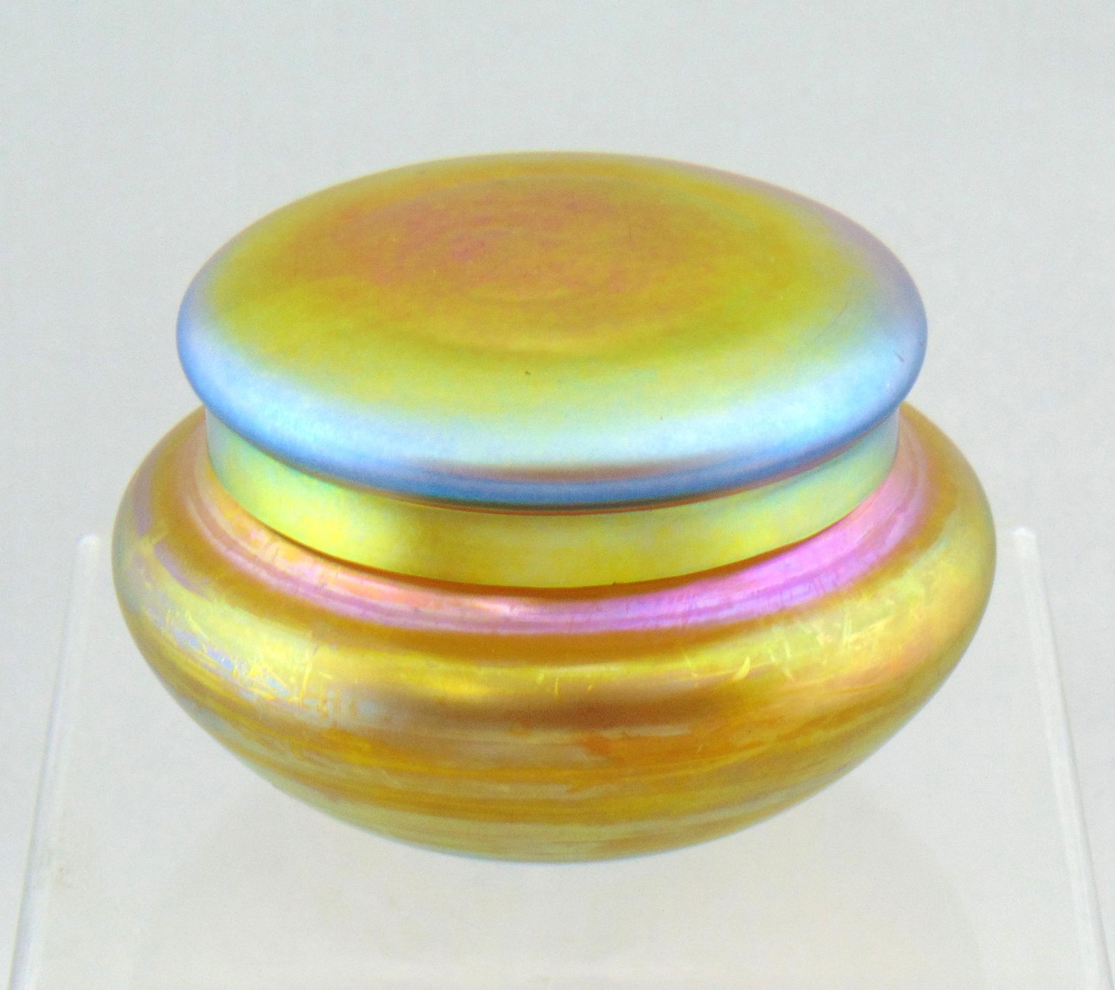 Steuben Gold Aurene dresser box: Ovoid form in Gold Aurene, signed Steuben Aurene 5204, 4" wide. Condition: good color but with minor pin chips to the fitter rim, see picture.